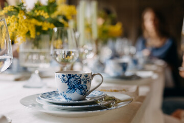 Vintage porcelain cup of coffee and plates on table.