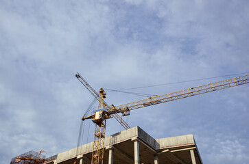 Tower crane building a house. Concrete building under construction