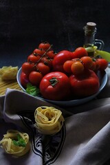 tagliatell pasta, various tomatoes in a bowl, bottle of olive oil, products of Italian cuisine, ingredients for a Mediterranean dish