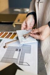 Close up of designer woman choosing details of new kitchen in home improvement store. Real estate, home renovation, small business concept