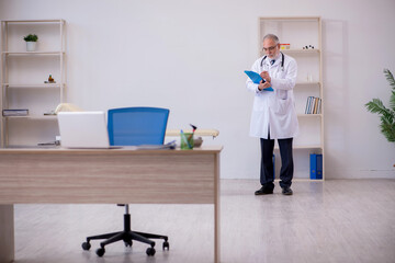 Old male doctor working in the clinic