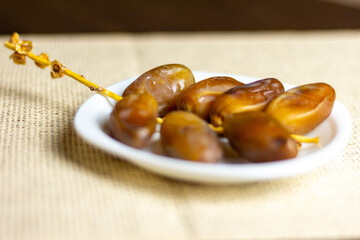Deglet Nour (date-palm of light) dates on a white plate,  Ramadan concept, space for text 