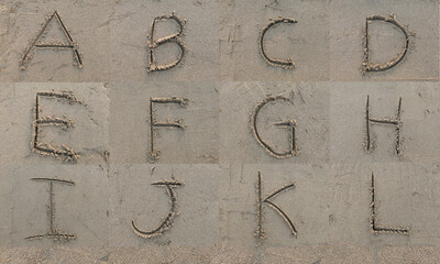 Character A B C D E F G H I J K L hand written on sand in evening