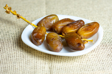 Deglet Nour (date-palm of light) dates on a white plate,  Ramadan concept, space for text 