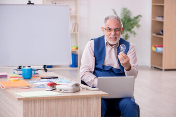 Old male designer working in the office