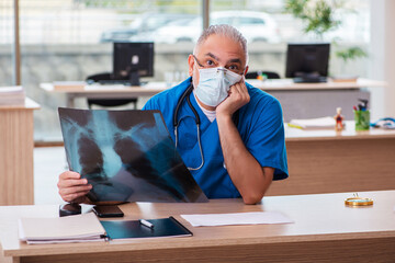 Old male doctor radiologist working in the clinic
