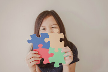 Young girl holding puzzle jigsaw,  child mental health concept, world autism awareness day, autism...