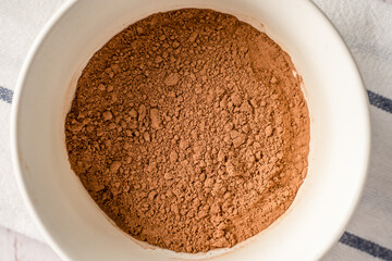 Close up top view on brown cocoa powder in a bowl