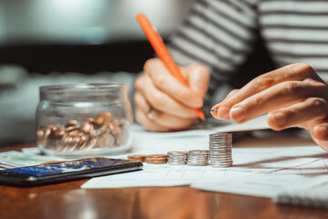 male businessman calculating stacking coin saving money for home financial accounting, retirement. Family expenses, taxes, checking debt balance making notes, Income paying bill online on computer 