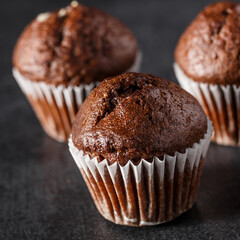 Chocolate cupcake with icing and chocolate bar in Dark lighting,Homemade delicious chocolate muffin on wooden background close-up