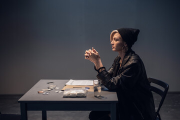 A girl suspected of distributing drugs sits at a table in an interrogation room.