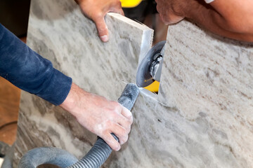 artisan cuts edges in marble kitchen countertop with hand circular saw