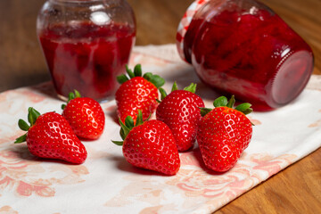 Homemade strawberry jam. Fresh strawberries and jars of freshly prepared jam.