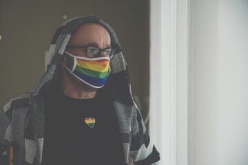 Medical LGBT mask in rainbow colors on male face. Covid 19 protection. Pandemic time.