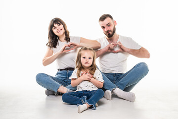 Young family with daughter sitting on the floor with hearth sign isolated on white background