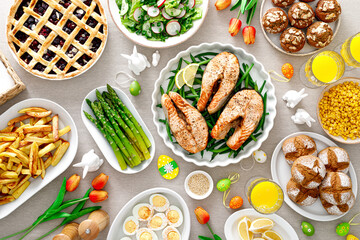 Easter festive table with salmon, asparagus, salad, potato, muffins and berry pie