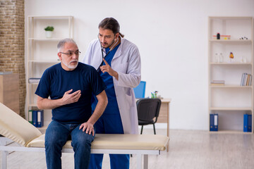 Fototapeta premium Old male patient visiting young male doctor
