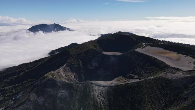 Iraz&uacute; Volcano highest active volcano in Costa Rica over clouds aerial shot Turrialba in background