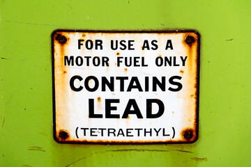 Leaded gasoline was the primary fuel type produced and sold in America until 1975, as depicted by this sign on an old gas pump ("contains lead (tetraethyl)). 