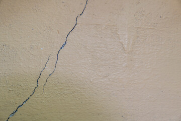 crack on the painted concrete wall. close-up. black and white cracked floor texture.