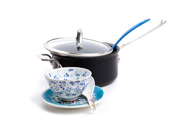 a soup black covered pot with a blue ladle and a blue soup bowl and oriental soup spoon isolated on...