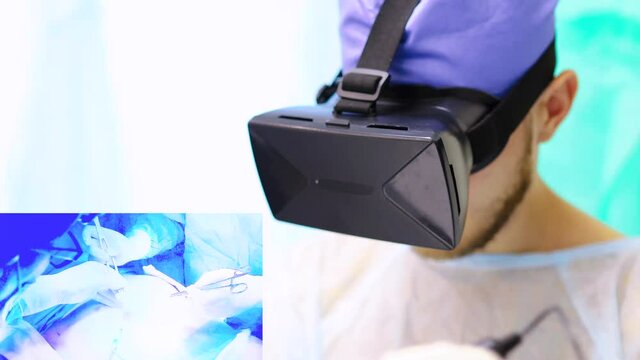 surgeon in a virtual reality headset uses controllers-manipulators to remotely control the treatment of a patient using a medical robot in a high-tech medical laboratory, a hologram displays the proce