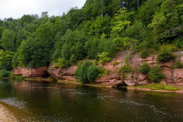 Fototapeta na wymiar landscape with sandstone cliffs on the river bank, fast flowing and clear river water, Kuku cliffs, Gauja river, Latvia