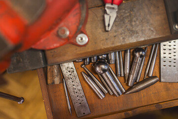 Metal forming tools on the table in a goldsmith's workshop.