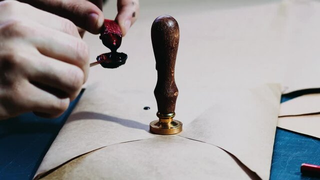 sealing craft envelopes with sealing wax, personalized brand and logo made of wax.
