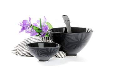 a black kitchen ladle in a group of modern black dishes isolated on white