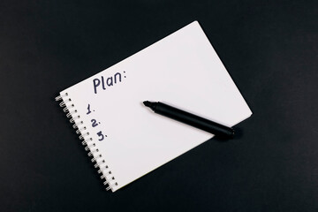 The word "plan" is written in the notebook, black marker