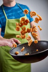Cook throwing red prawns with a wok
