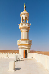 The minaret of a mosque in the desert of Oman.
