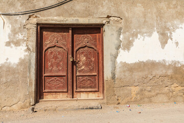 Carved wooden door on a building in Oman.
