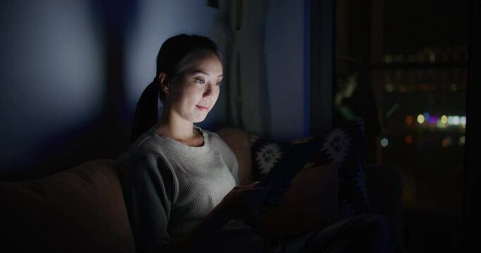 Woman work on tablet computer at home in the evening