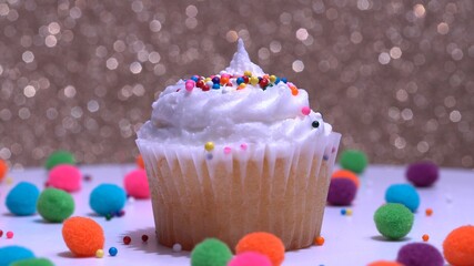 Cupcake macro shallow depth of field and decoration with sugar sprinkles. Cup cake with white vanilla cream on gold background. Process of making delicious desserts muffin for delivery or sale.