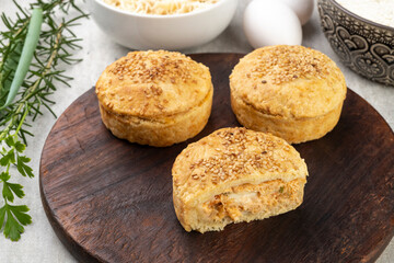 Homemade chicken pies over wooden board with ingredients