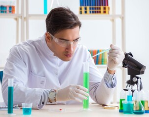 Young chemist student working in lab on chemicals