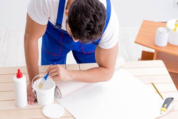Obraz na płótnie Canvas Worker working on wallpaper during refurbishment
