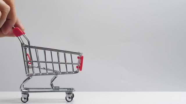 walnuts are poured into the grocery cart when filling it. shopping cart from a supermarket on a white background filled with nuts