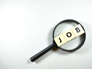 Selective focus.Magnifying glass and scrabble letters with text JOB on white background.