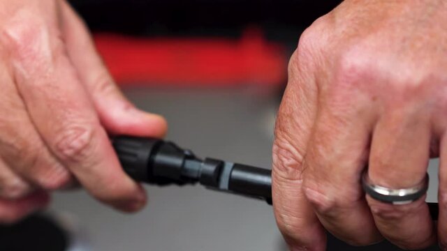 This is a High Definition footage, at 23.976 fps, of a technician connecting a solar panel MC4 cable. It is a close up with shallow aperture.