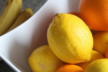 Bowl of  orange and yellow fruit. 