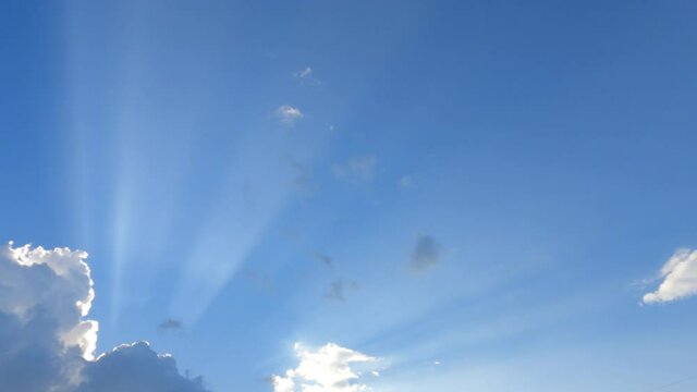Bright sun light ray flare shing through cloud on blue sky