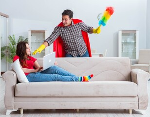 Obraz premium Superhero husband helping his wife at home