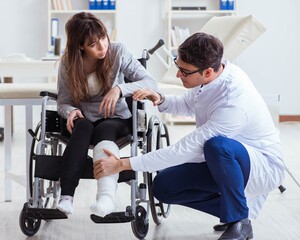 Male doctor examining female patient on wheelchair