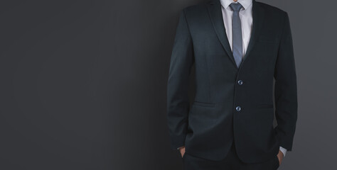 Close up of businessman in black suit and necktie, black background. Copy space for advertising.