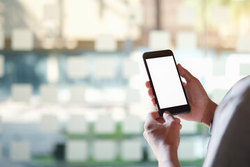 Close up view of business holding mobile phone with blank screen.	