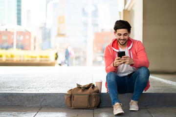 Young man using his mobile phone outdoors.