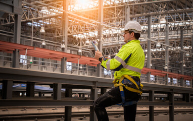 Engineer under inspection and checking construction process railway and checking work on railroad station .Engineer wearing safety uniform and safety helmet in work.